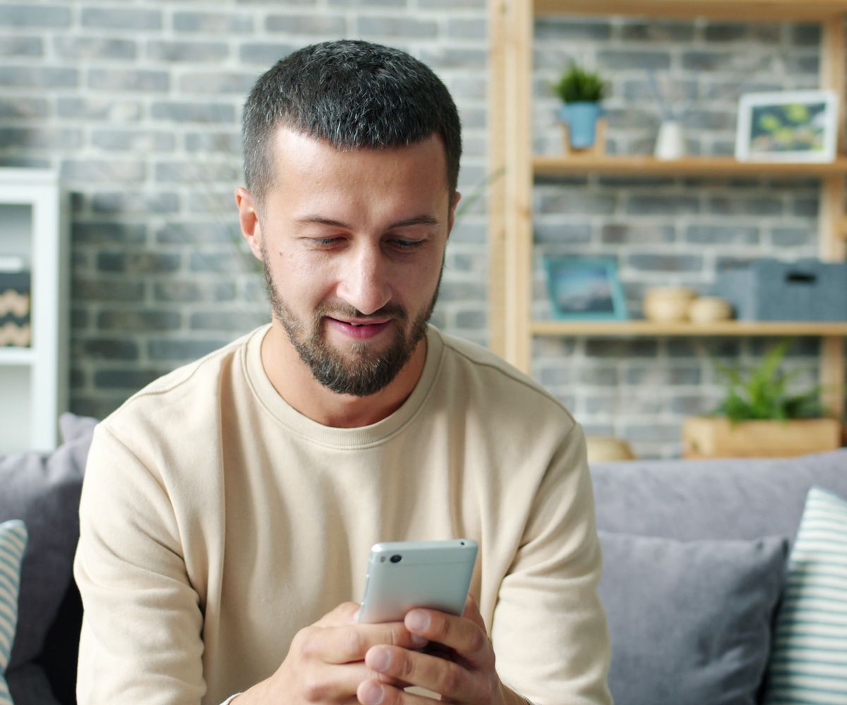 A person smiling while setting up their home from the Ambryon app on their phone